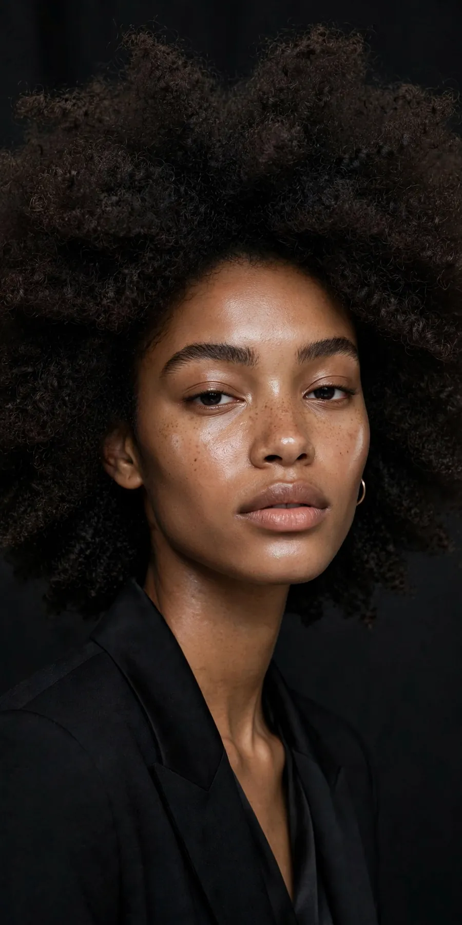 Beauty portrait of a model with natural hair against a dark backdrop
